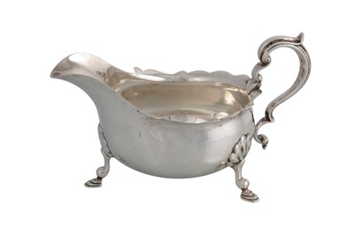 Lot 593 - AN EDWARDIAN SILVER HELMET SHAPED SAUCE BOAT,...