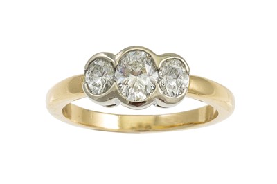 Lot 239 - A THREE STONE DIAMOND RING, set with oval...