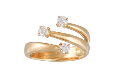 Lot 175 - A DIAMOND CROSS OVER RING, set with three...