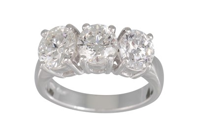 Lot 243 - A THREE STONE DIAMOND RING, the brilliant cut...