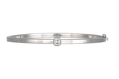 Lot 318 - A DIAMOND BANGLE, the emerald cut diamond...