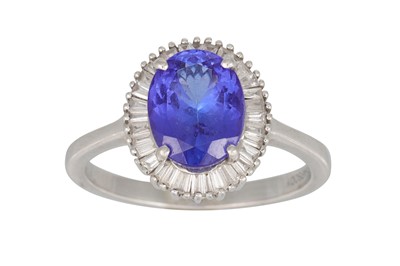 Lot 356 - A TANZANITE AND DIAMOND CLUSTER RING, the oval...