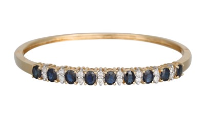 Lot 279 - A SAPPHIRE AND DIAMOND BANGLE, each oval...