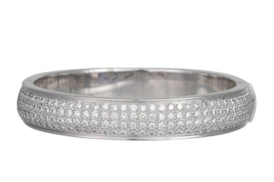 Lot 401 - A DIAMOND SET BANGLE, set with four rows of...
