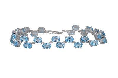 Lot 26 - A BLUE TOPAZ AND DIAMOND BRACELET, the oval...