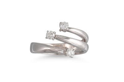 Lot 187 - A DIAMOND CROSS OVER RING, set with three...