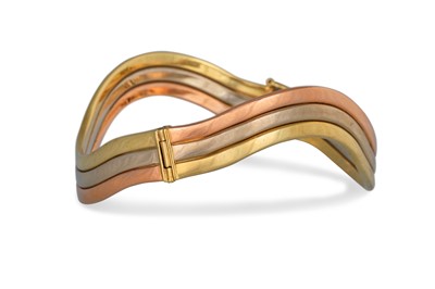 Lot 280 - A 9CT THREE COLOUR GOLD BANGLE, wavy form, 18 g.
