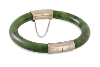 Lot 136 - A JADE BANGLE, silver mounts