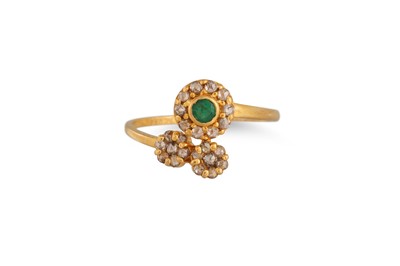 Lot 428 - A DIAMOND AND EMERALD DRESS RING, of twist...