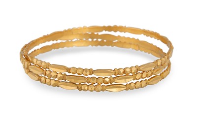 Lot 49 - A GROUP OF THREE 20CT GOLD BANGLES, ornate...