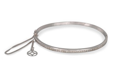 Lot 213 - A DIAMOND BANGLE, the channel set with...