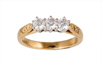 Lot 288 - A THREE STONE DIAMOND RING, the brilliant cut...
